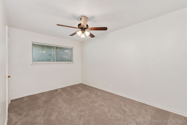 empty room featuring ceiling fan and light colored carpet