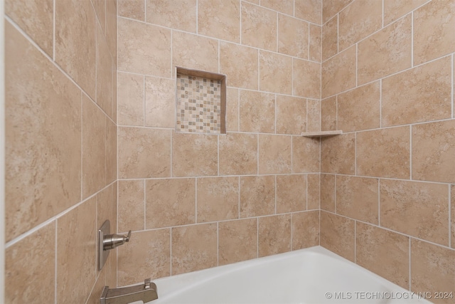 bathroom featuring tiled shower / bath