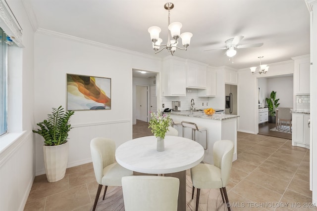 tiled dining room with ornamental molding, ceiling fan with notable chandelier, and sink