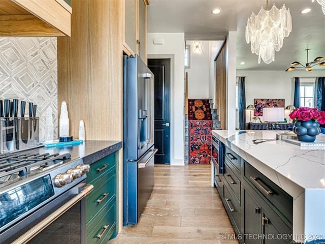 46 Redbud St, Carlton Landing, OK 74432 - kitchen with stainless steel appliances, a chandelier, light wood-style flooring, light stone counters, and decorative light fixtures