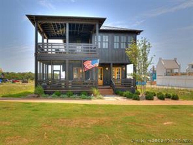 view of front of house with a balcony and a front lawn