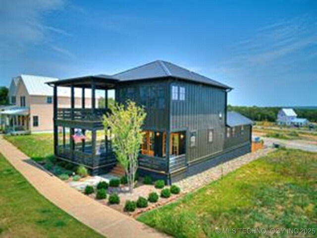 46 Redbud St, Carlton Landing, OK 74432 - rear view of house with board and batten siding, a deck, and a lawn
