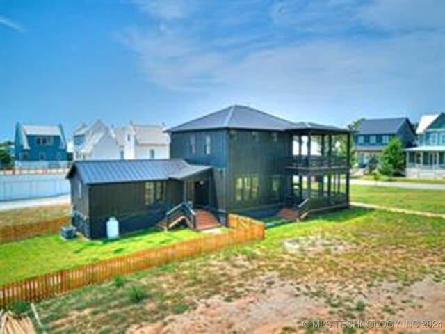 rear view of house with a residential view, an outbuilding, and a yard