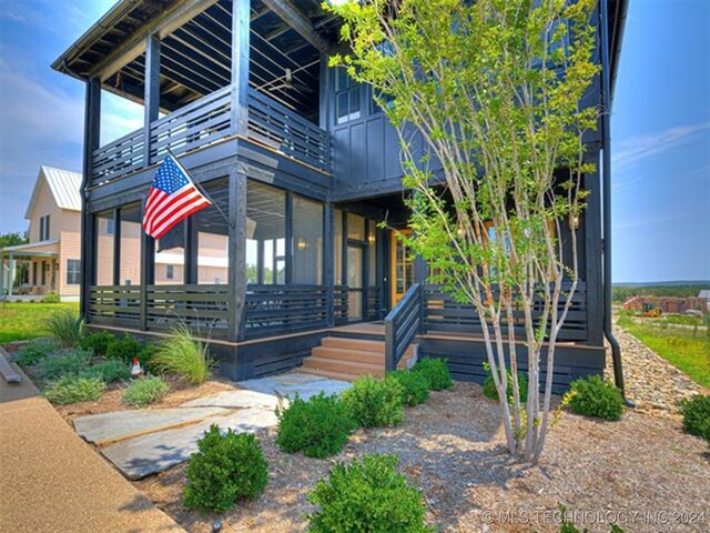 view of side of property with a balcony, metal roof, and a porch