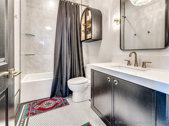 bathroom with shower / bath combo, vanity, and toilet