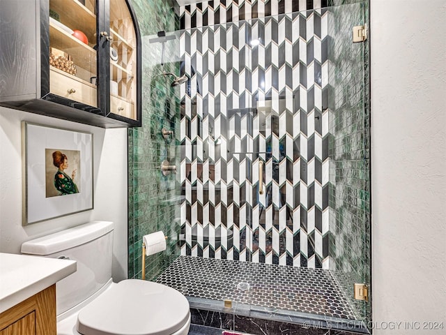 full bath featuring toilet, a stall shower, vanity, and a textured wall