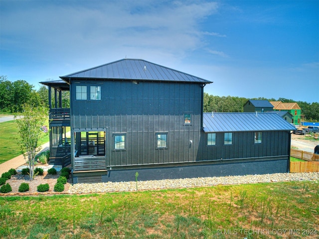 view of side of home with metal roof, a yard, and a standing seam roof