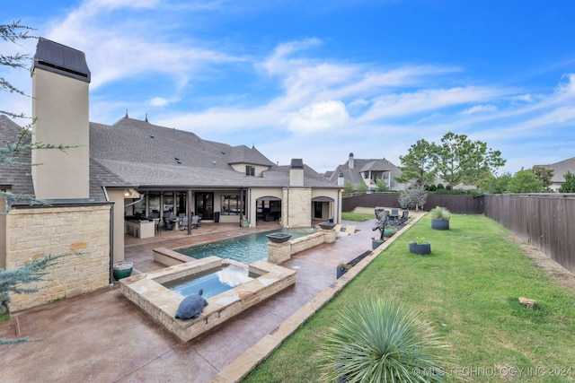 view of swimming pool with an in ground hot tub, a lawn, and a patio area