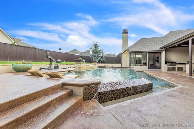 view of swimming pool featuring a patio area, area for grilling, and pool water feature