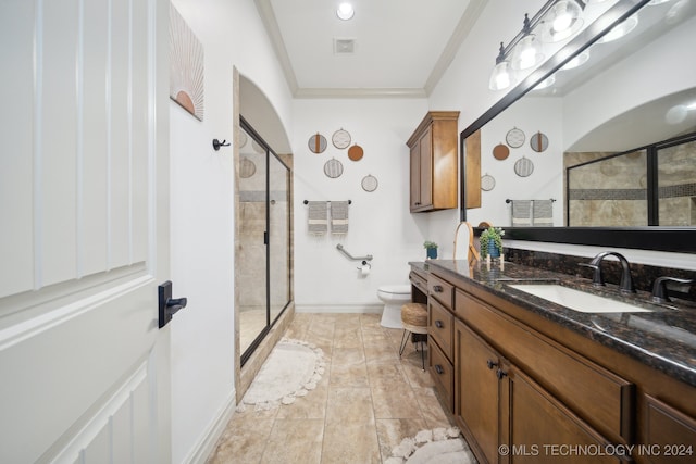 bathroom featuring toilet, a shower with door, crown molding, and vanity