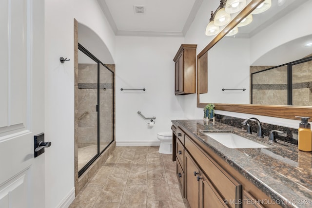 bathroom with crown molding, vanity, toilet, and an enclosed shower