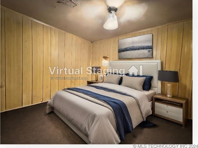 bedroom featuring wood walls and dark colored carpet