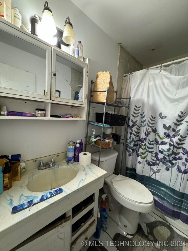 bathroom with walk in shower, vanity, and toilet