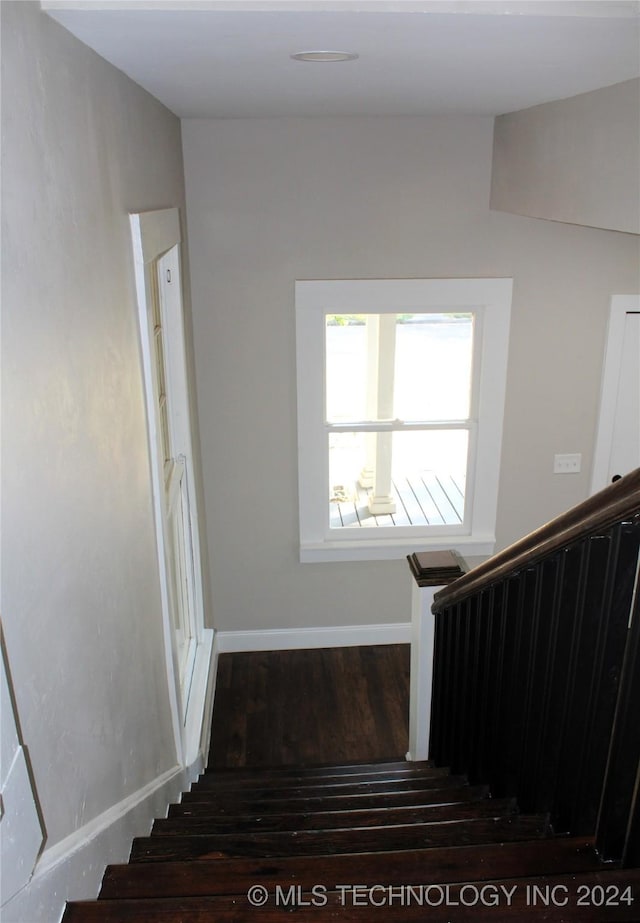 stairway with baseboards and wood finished floors