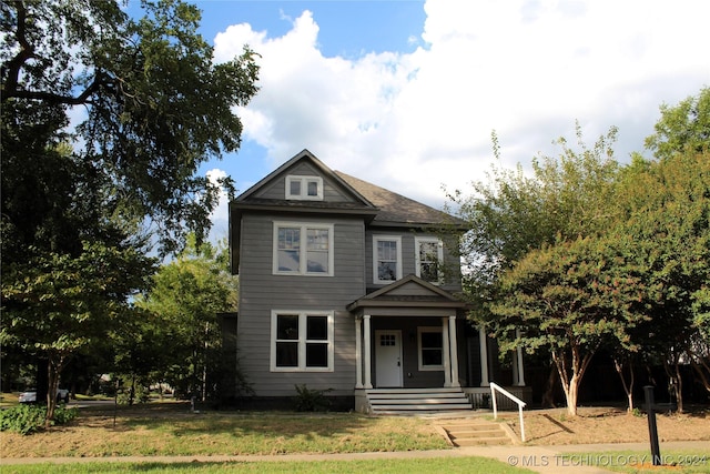 view of front facade featuring covered porch and a front lawn