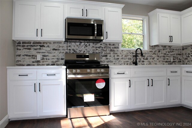 kitchen featuring dark wood-type flooring, white cabinets, appliances with stainless steel finishes, and tasteful backsplash