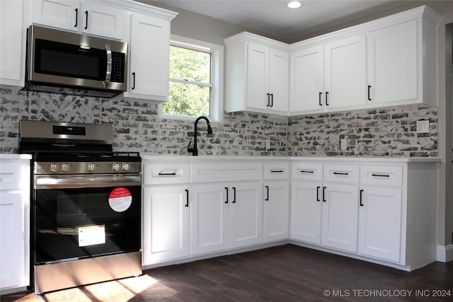 kitchen featuring white cabinets, dark wood-style floors, appliances with stainless steel finishes, and decorative backsplash