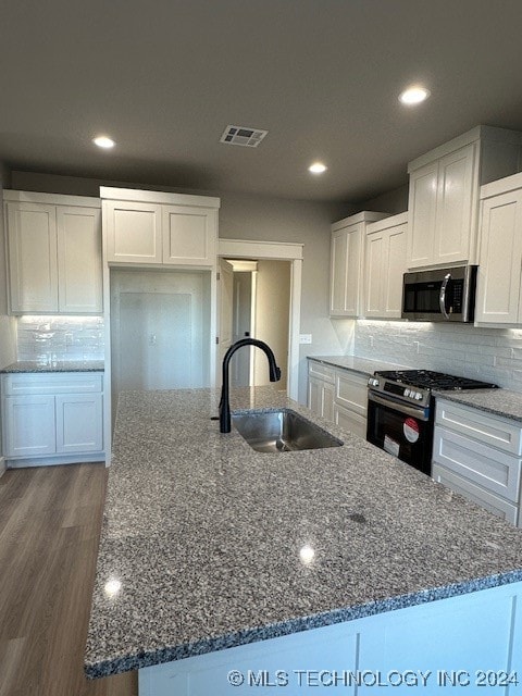 kitchen featuring white cabinetry, a kitchen island with sink, and appliances with stainless steel finishes