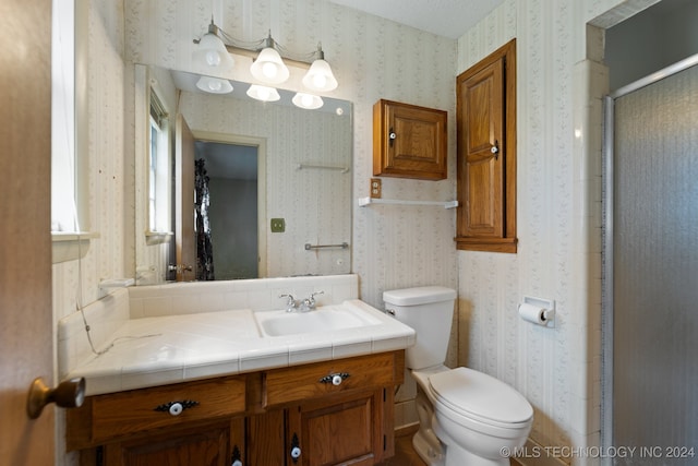 bathroom featuring vanity, toilet, and walk in shower