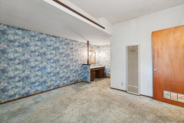 unfurnished bedroom featuring a textured ceiling, carpet flooring, and connected bathroom