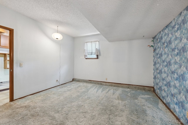 carpeted spare room with a textured ceiling