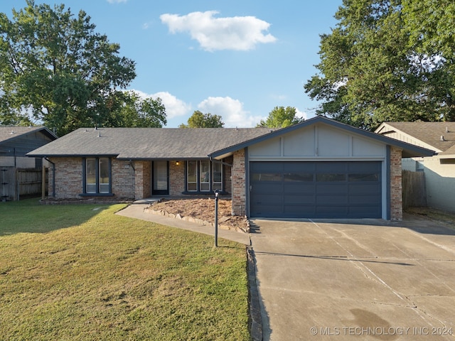 ranch-style house featuring a garage and a front lawn