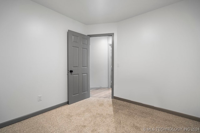 unfurnished room featuring light carpet