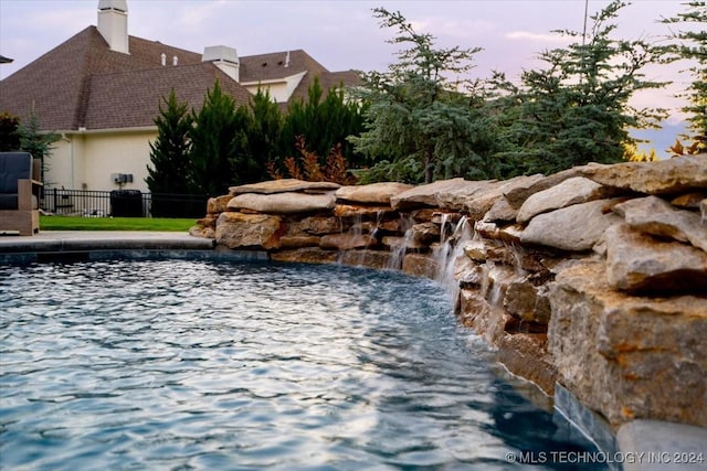 view of pool at dusk