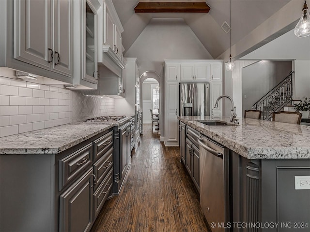 kitchen with stainless steel appliances, an island with sink, hanging light fixtures, and sink