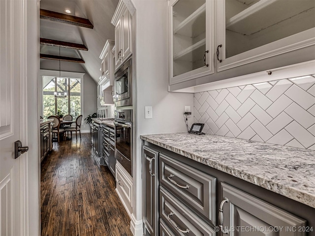 kitchen with vaulted ceiling with beams, tasteful backsplash, light stone counters, dark hardwood / wood-style flooring, and stainless steel appliances