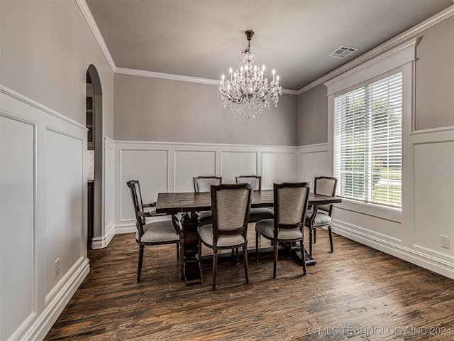 dining area with an inviting chandelier, dark wood-type flooring, and ornamental molding