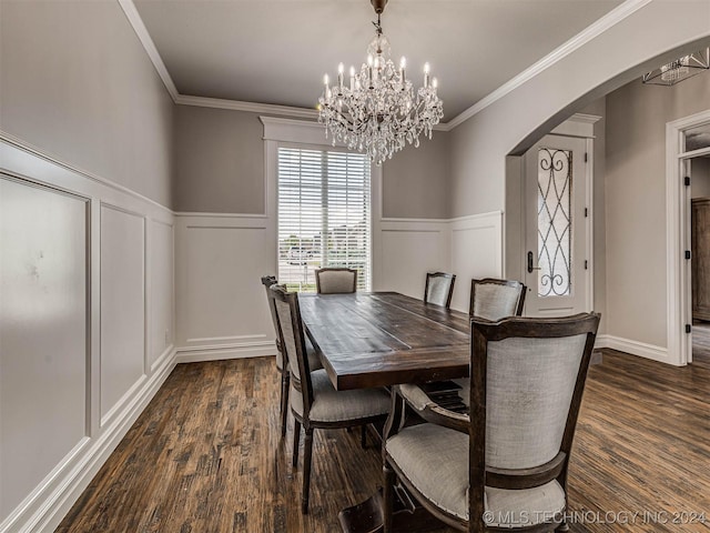 dining area featuring crown molding, dark wood-type flooring, and a notable chandelier