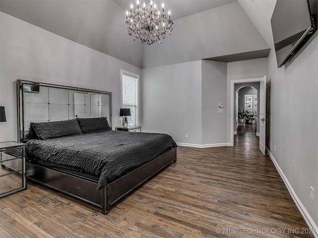 bedroom featuring dark hardwood / wood-style flooring, high vaulted ceiling, and a notable chandelier