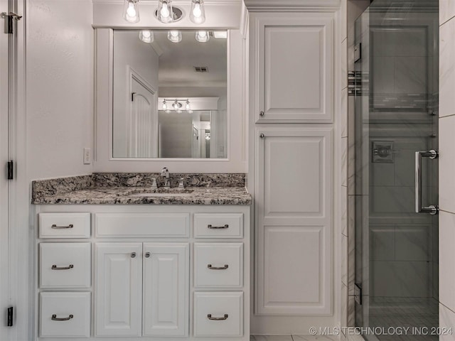 bathroom with vanity and a shower with shower door