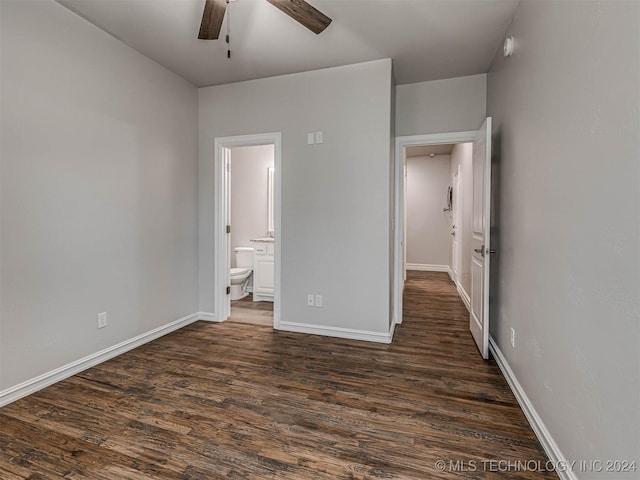 unfurnished bedroom with ceiling fan, ensuite bathroom, and dark hardwood / wood-style flooring