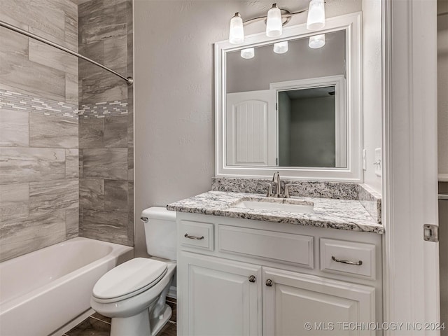 full bathroom featuring tiled shower / bath combo, vanity, and toilet