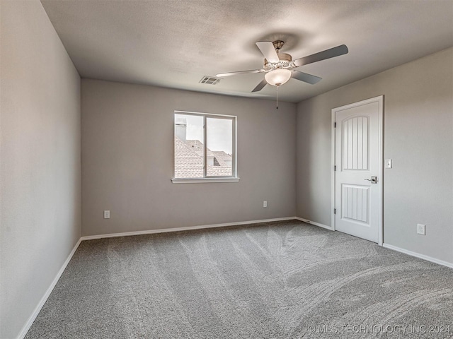 carpeted spare room featuring a textured ceiling and ceiling fan