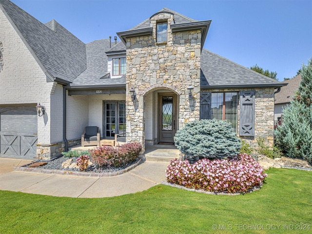 french country style house with a garage and a front yard