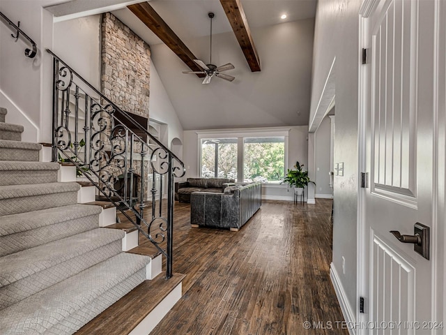 stairway with hardwood / wood-style floors, beam ceiling, high vaulted ceiling, and ceiling fan