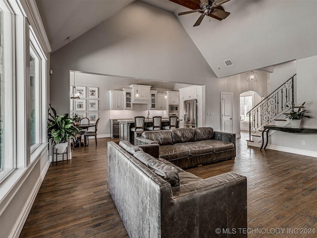 living room with ceiling fan, dark hardwood / wood-style floors, and high vaulted ceiling