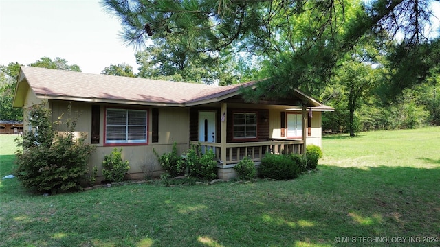 single story home with a shingled roof, a porch, and a front yard