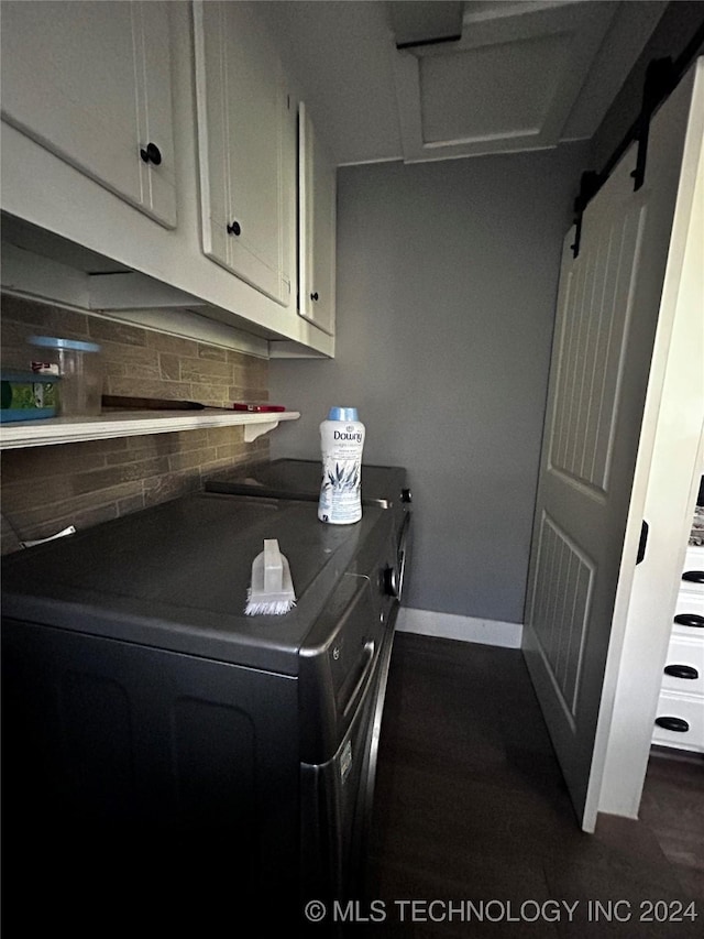 washroom featuring separate washer and dryer, attic access, cabinet space, dark wood finished floors, and baseboards