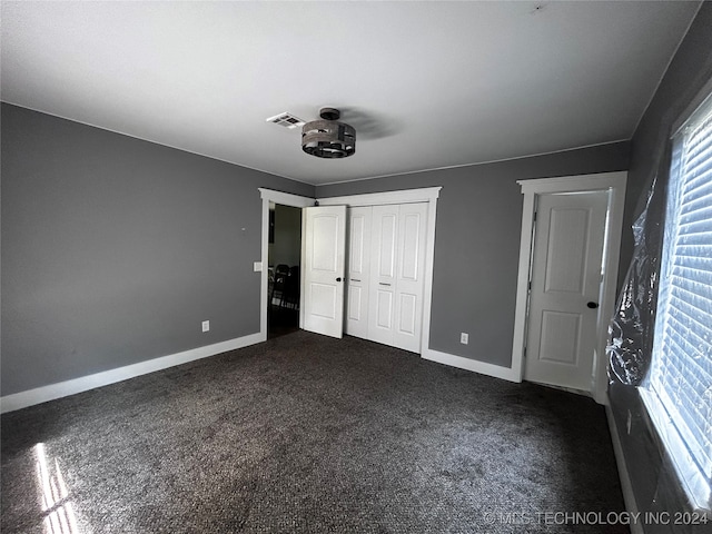 unfurnished bedroom featuring dark carpet and ceiling fan