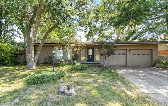 ranch-style house with a garage and a front lawn