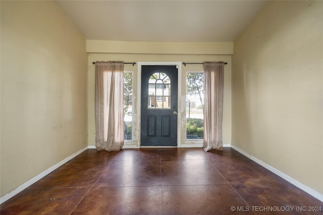 entrance foyer with concrete flooring and baseboards