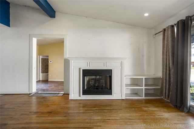 unfurnished living room with a fireplace, vaulted ceiling with beams, baseboards, and wood finished floors