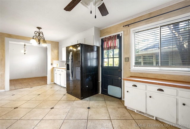 kitchen with white cabinets, black refrigerator with ice dispenser, and light tile patterned floors