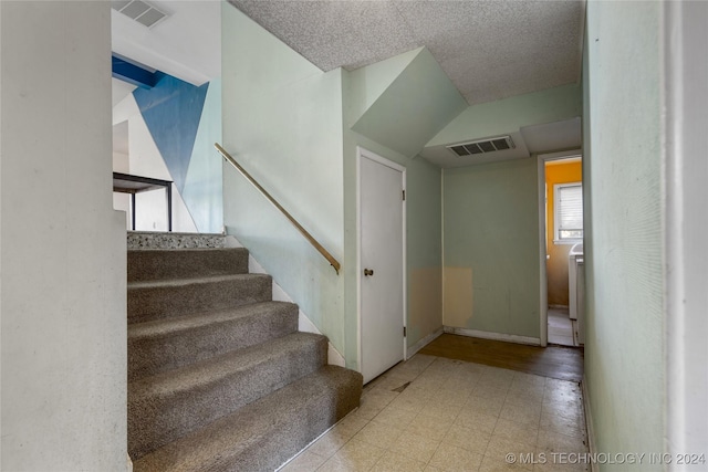 staircase with baseboards, visible vents, and tile patterned floors