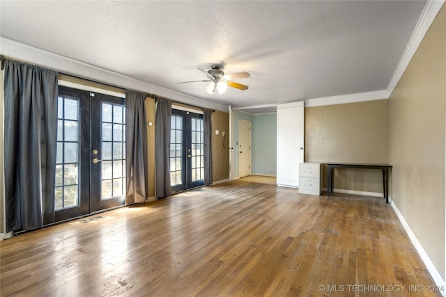 spare room featuring baseboards, hardwood / wood-style flooring, ornamental molding, a textured ceiling, and french doors