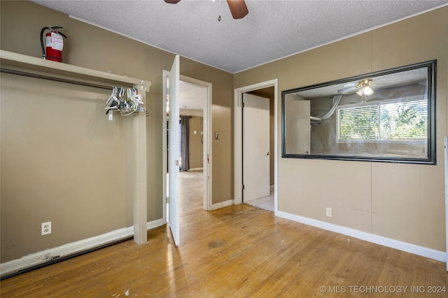 unfurnished bedroom with baseboards, a textured ceiling, a ceiling fan, and hardwood / wood-style floors